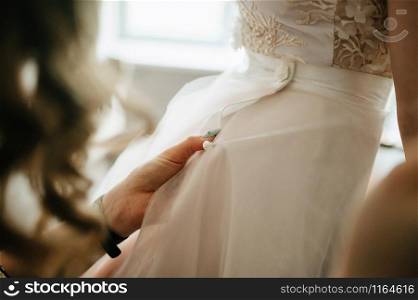 White wedding dress hanging in the bedroom. White bride dress close up. White wedding dress hanging in the bedroom. White bride dress