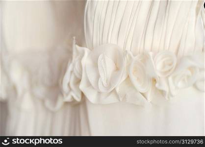 white wedding dress hangs on hanger close up