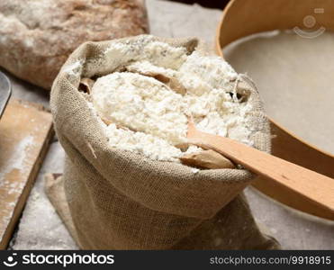 white wheat flour in a small burlap sack, close up