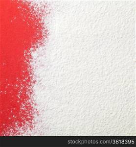 White wheat flour looks like snow on red paper background. Top view. Copy space