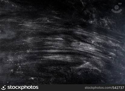 white wheat flour scattered on a black table, top view, culinary background