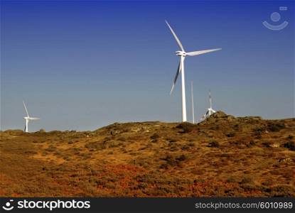 white wind turbine in the top of the mountain