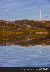 White wind turbines at the top of the mountain