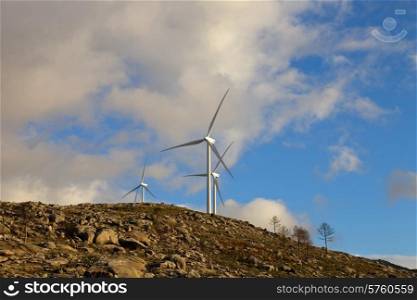 white wind turbines in the top of the mountain