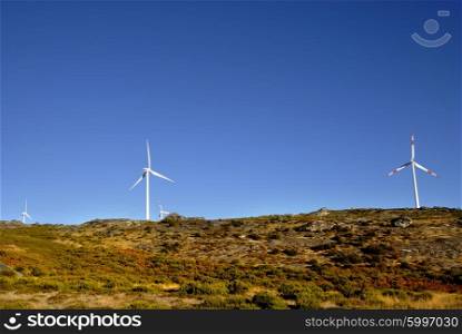 white wind turbines in the top of the mountain