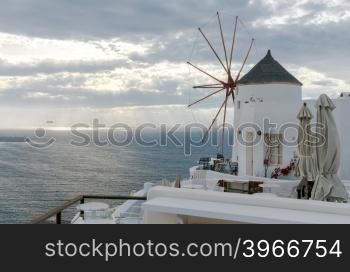 White windmills at sunset in the village Oia. Santorini. Greece.. Oya. White windmills.