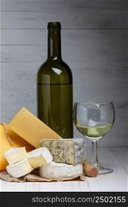 White wine and cheese on wooden table