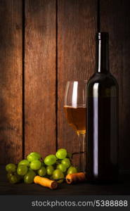 White wine, grapes, corkscrew, and bottle on wood background closeup