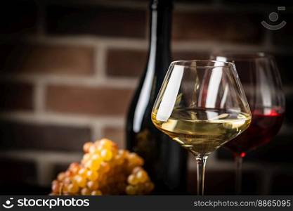 White wine in a glass with fall grapes, dark wooden background. White wine in a glass