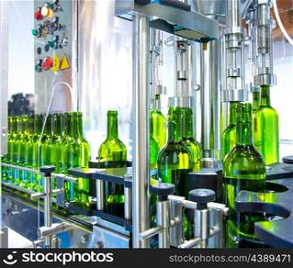white wine in glass bottling machine at winery