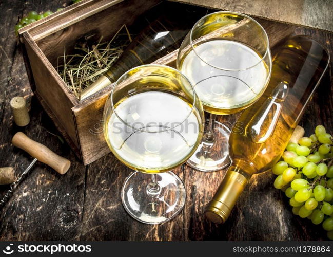 White wine in glasses. On a wooden background.. White wine in glasses.