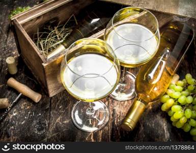 White wine in glasses. On a wooden background.. White wine in glasses.