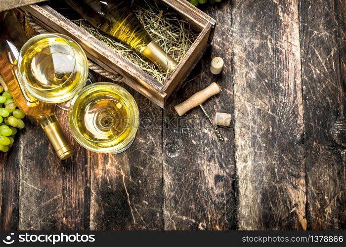 White wine in glasses. On a wooden background.. White wine in glasses.