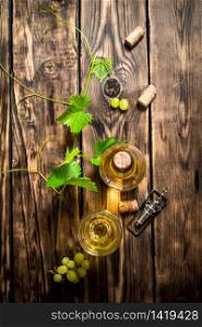 White wine in the vine. On a wooden table.. White wine in the vine.
