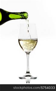 White wine pouring into glass isolated on white background. White wine pouring