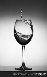 White wine splash on gray background. silhouette of a glass. selective focus.. White wine splash on gray background. silhouette of a glass. selective focus