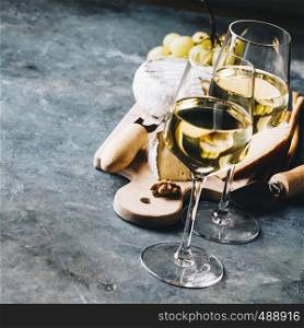 White wine with charcuterie assortment on the stone background. Wine and snack set
