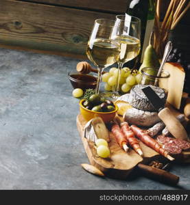 White wine with charcuterie assortment on the stone background. Wine and snack set