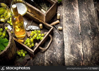 White wine with fresh grapes on an old tray. On a wooden background.. White wine with fresh grapes on an old tray.