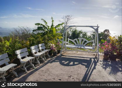 White wooden bench and flowers in the garden