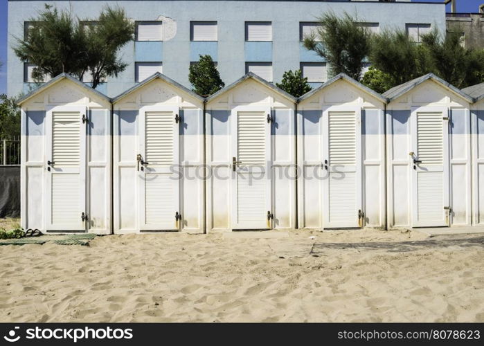 White wooden cabins on the beach.