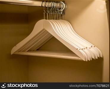 white wooden clothes hanger in the closet