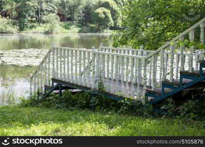 White wooden gangway with railings on the lake