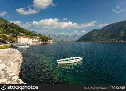 White wooden rowboat mooring at bay of Kotor in Perast city at sunny day