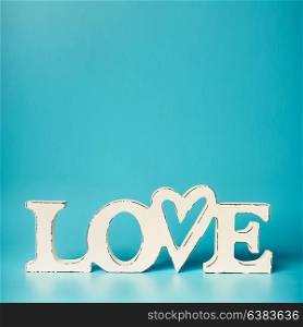 White word LOVE on turquoise blue background, front view. Modern layout or mock up for card or greeting
