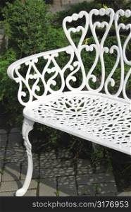 White wrought iron bench in a garden