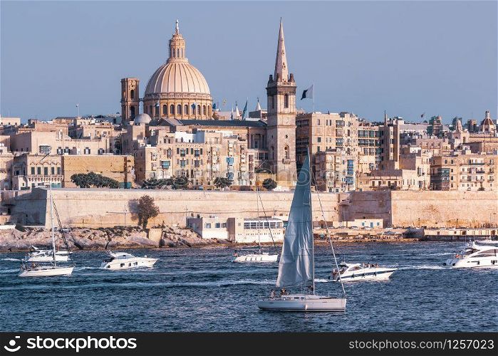 White yacht and boats in harbor of Valletta, Our Lady of Mount Carmel church and St. Paul&rsquo;s Anglican Pro-Cathedral on the background, Valletta, Malta. Valletta as seen from Sliema, Malta