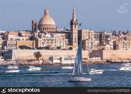 White yacht and boats in harbor of Valletta, Our Lady of Mount Carmel church and St. Paul&rsquo;s Anglican Pro-Cathedral on the background, Valletta, Malta. Valletta as seen from Sliema, Malta