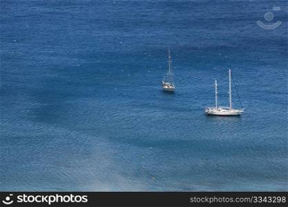White yachts in blue sea, aerial view. Plaka, Crete, Greece.. White sailing boats in blue sea, aerial view.