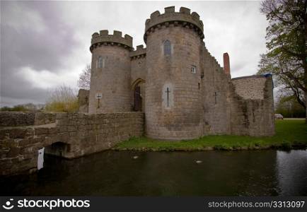 Whittington Castle in Shropshire reflected in moat with cloudy sky