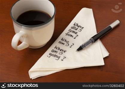 Who am I and other spiritual life questions - handwrting on napkin with coffee cup on wooden table