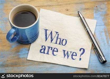 Who are we question - handwriting on a napkin with a cup of espresso coffee