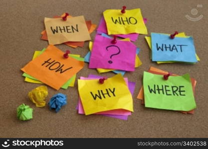 who, what, where, when, why, how questions - uncertrainty, brainstorming or decision making concept, colorful crumpled sticky notes on cork bulletin board
