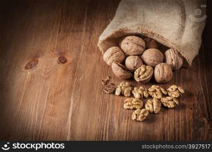 Whole and chopped walnuts on old wooden table