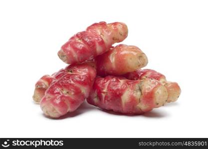 Whole and half fresh pink Oca on white background