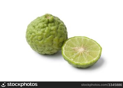 Whole and half Kaffir lime on white background