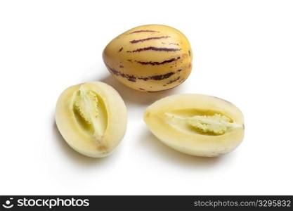 Whole and half Pepino melons on white background