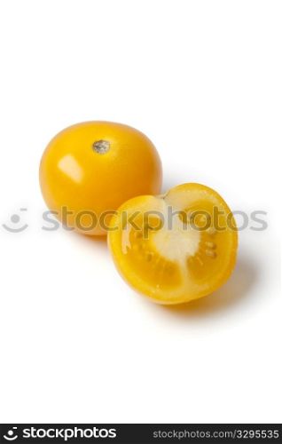 Whole and half yellow tomato isolated on white background