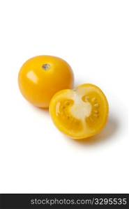 Whole and half yellow tomato isolated on white background