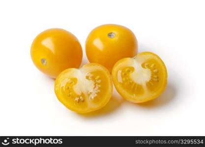 Whole and half yellow tomatoes on white background