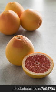 Whole and halved fresh juicy red grapefruit