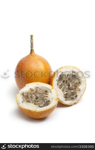 Whole and partial orange passion fruit on white background