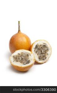 Whole and partial orange passion fruit on white background