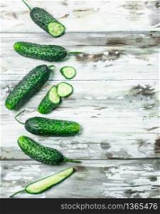 Whole and sliced cucumbers. On wooden background. Whole and sliced cucumbers.