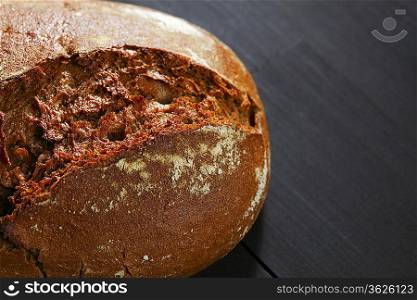 Whole black bread on table