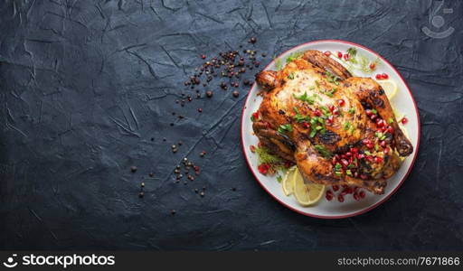 Whole chicken baked with pomegranate.Appetizing meat.Flat lay. Delicious baked chicken on table